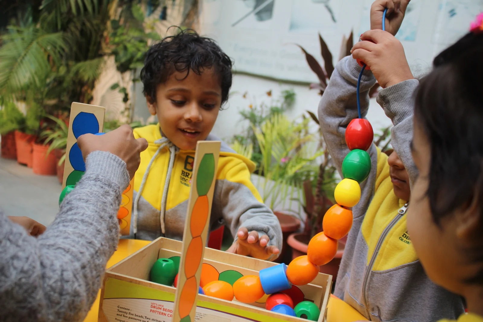 Children arranging colourful beads during a pattern activity
