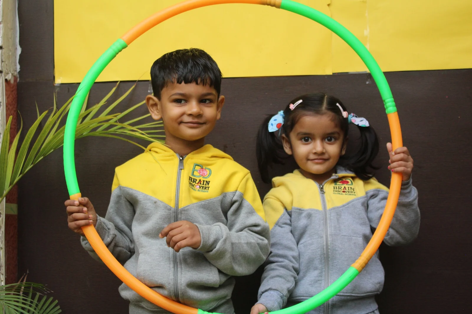Students posing together with a colourful activity hoop