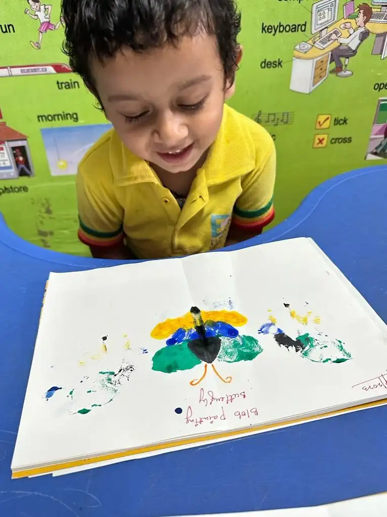 A young student creating a colourful finger painting